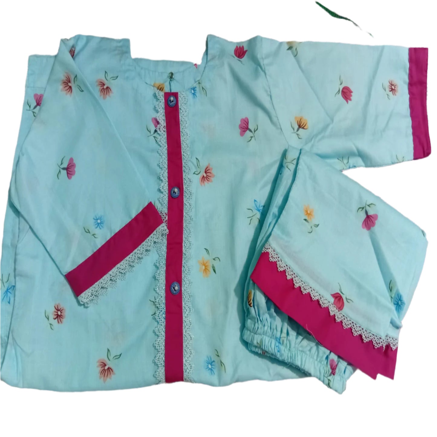 Light blue children's outfit with pink accents on a patterned fabric background