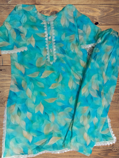 Turquoise floral dress with lace trim on a wooden surface